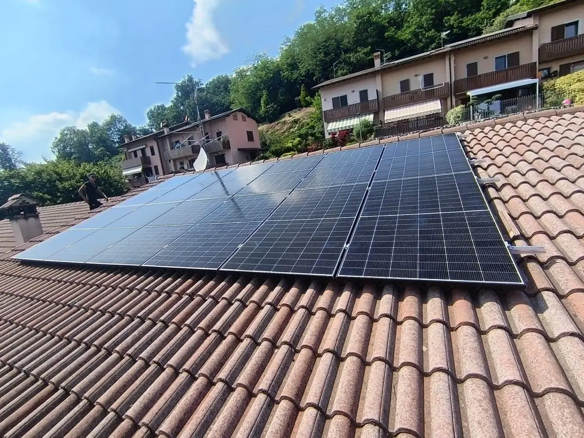 Elettricista al lavoro su un impianto fotovoltaico su tetto in coppi
